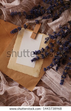 Stack of vintage photos on a wooden table with lavender flowers