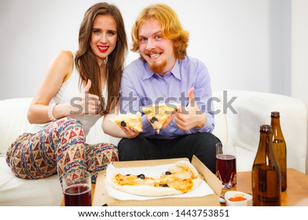 Funny crazy man and woman spending time together. Cheerful couple or friends eating delicious cheesy pizza.