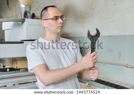Portrait of industrial worker with tool, workman holding wrench or spanner