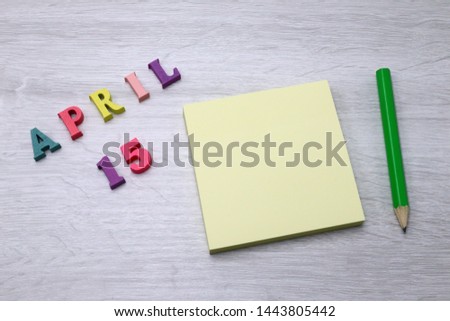 April 15 - Daily colorful Calendar with Block Notes and Pencil on wood table background, empty space for your text or design 