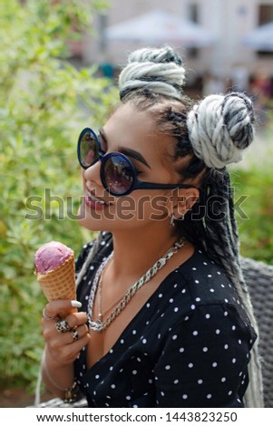 Beautiful young woman with white dreadlocks eating ice cream. Summer time.