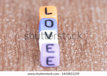 Love wording from alphabet beads on a wooden surface. selective focus 