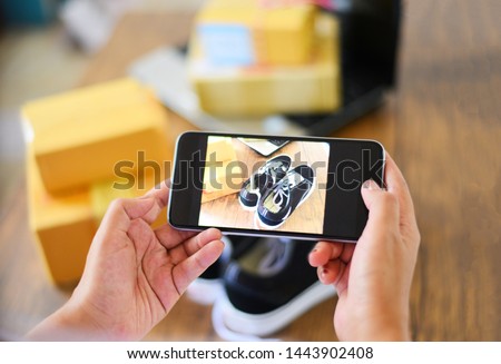 young woman taking photo sneakers with camera smartphone for post to sell online on the internet market website / selling online ecommerce shipping online shopping delivery and order concept Royalty-Free Stock Photo #1443902408
