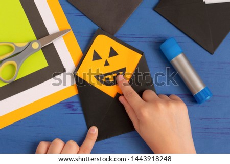 How to make original envelopes for Halloween greetings. Children's art project. DIY concept. Step-by-step photo instruction. Step 12. Glue details of Jack lantern
