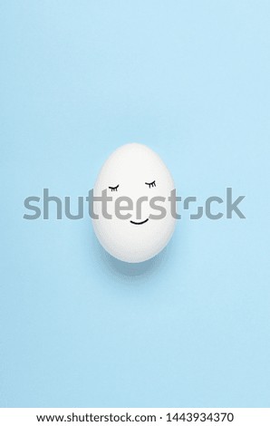 Kawaii faces on white eggs on a blue background. Cartoons, decoration food for children. Top view, flat lay.