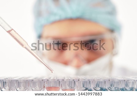 Pharmacist dropping test liquid into multiple cells