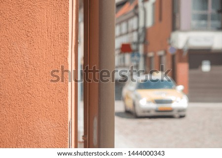 The car passes through a narrow street of the city of Klaipeda. Part of the wall. Drainpipe along the wall.