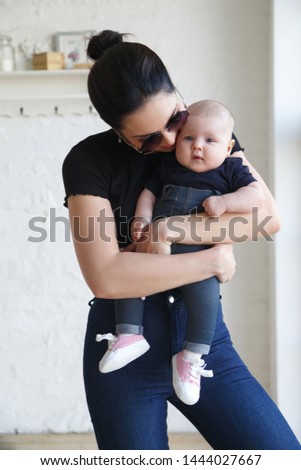 Young stylish mother with a baby in her arms.