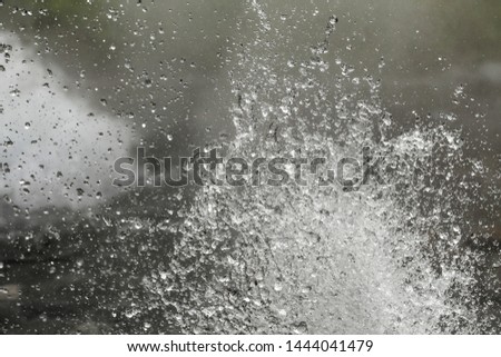 The big sea waves crashing coastal rock in storm, splashing water and white bubble foam air isolated on blurred light and dark background.