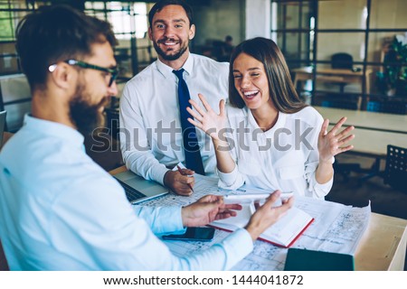 Portrait of cheerful businessman enjoying collaborating and socialising with male and female partners during break in office, successful cheerful men and woman laughing from video on digital tablet Royalty-Free Stock Photo #1444041872