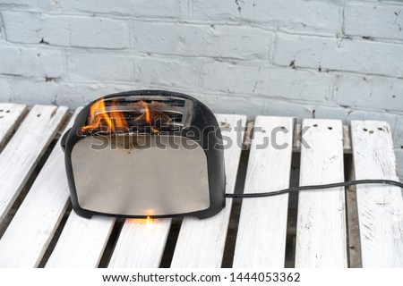 Burning toaster. Toaster with two slices of toast caught on fire over white background. Danger of careless handling of electrical appliances. Fire Royalty-Free Stock Photo #1444053362