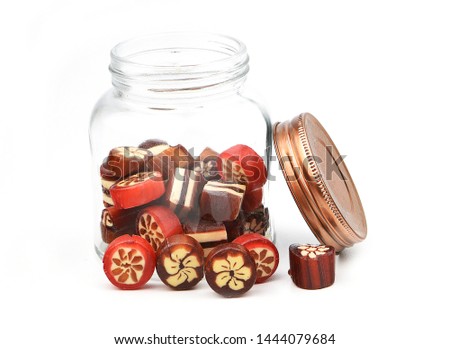 close up homemade hard sugar candy,boiled sweet in glass jar and lid isolated on white background