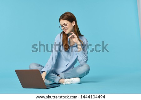 woman works with a laptop on a blue background