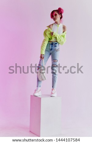 a woman with pink hair is standing in a neon cube studio fashion
