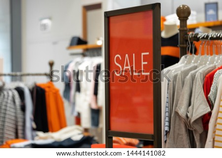 goods in stores and a red sign on sales discounts. mocap for text and concept of sales and trade in light industry. sign with advertising discounts in the store
