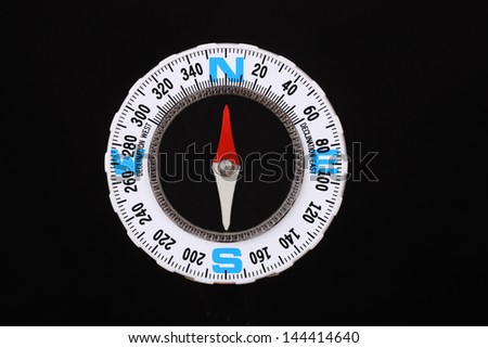 Close up of a compass on black background