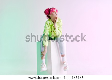 woman with pink hair in jeans sitting on a cube retro fashion style