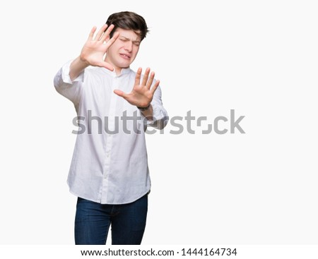 Young handsome business man over isolated background afraid and terrified with fear expression stop gesture with hands, shouting in shock. Panic concept.