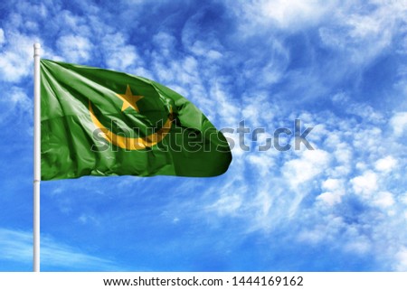 National flag of Mauritania on a flagpole in front of blue sky