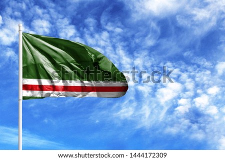 National flag of Chechen Republic of Ichkeria on a flagpole in front of blue sky