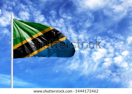 National flag of Tanzania on a flagpole in front of blue sky