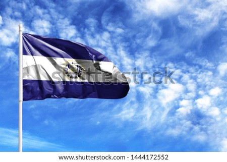 National flag of El Salvador on a flagpole in front of blue sky