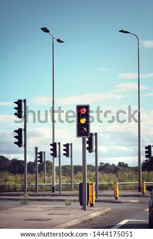 Traffic lights for cars on a road changing from red orange to green