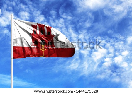 National flag of Gibraltar on a flagpole in front of blue sky