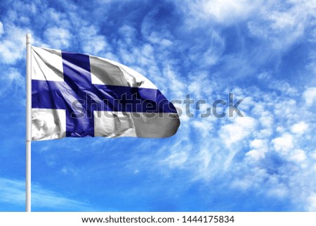 National flag of Finland on a flagpole in front of blue sky