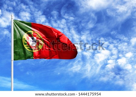 National flag of Portugal on a flagpole in front of blue sky