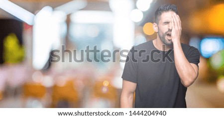 Young handsome man over isolated background Yawning tired covering half face, eye and mouth with hand. Face hurts in pain.