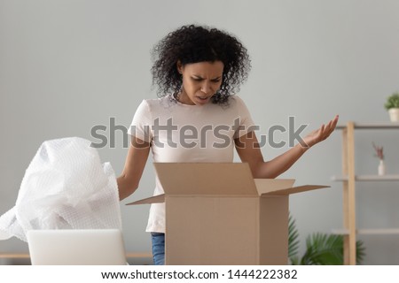 Disappointed shocked frustrated african woman customer open cardboard box receive damaged wrong parcel, annoyed black girl consumer having problem with bad shopping order displeased by post shipping Royalty-Free Stock Photo #1444222382