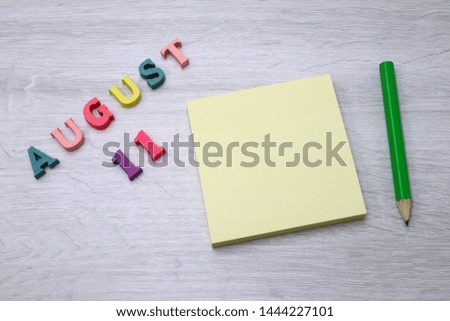 August 11 - Daily colorful Calendar with Block Notes and Pencil on wood table background, empty space for your text or design