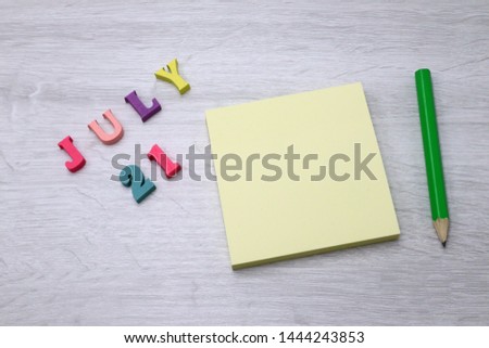 July 21 - Daily colorful Calendar with Block Notes and Pencil on wood table background, empty space for your text or design