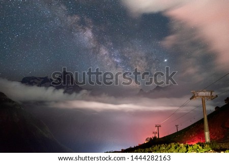 night sky with stars over the mountains with clouds in the mountain