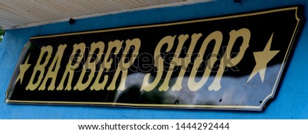 Closeup of barber shop sign with stars on blue exterior