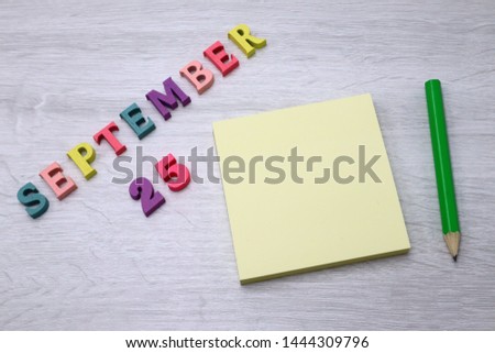 September 25 - Daily colorful Calendar with Block Notes and Pencil on wood table background, empty space for your text or design 