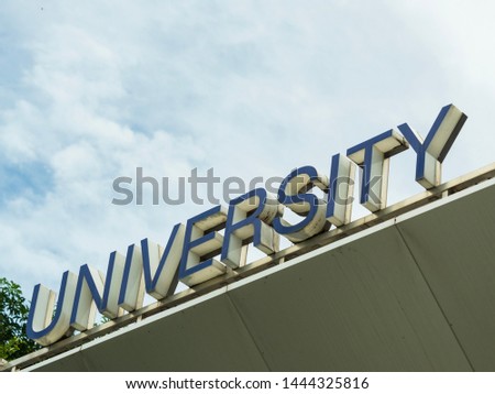 University letter signage over the cloudy sky background. 