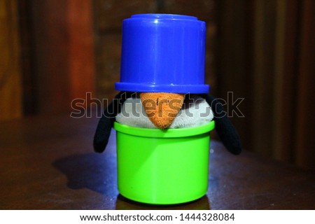 plush penguin inside colorful toy pots