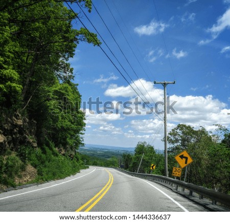 blue skies, clouds, winding Mountain road