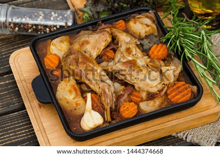 Diet rabbit legs, baked in the oven with vegetables, potatoes, zucchini, carrots, tomatoes, onions and garlic. 