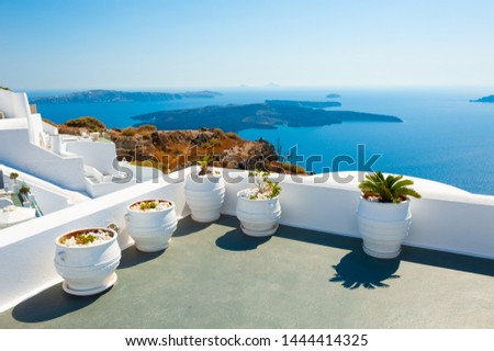 White architecture on Santorini island, Greece. Flowers on the terrace with sea view. 