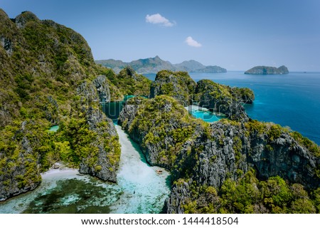 Aerial drone view of turquoise big and small lagoons surrounded by steep rocks, Marine National Reserve in El Nido, Palawan Royalty-Free Stock Photo #1444418504