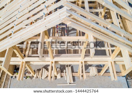 The wooden skeleton of the house top view. Construction site. Wooden frame of the home from a bar. The house wooden foundation. Building of houses under the key. Production of wooden houses. Royalty-Free Stock Photo #1444425764