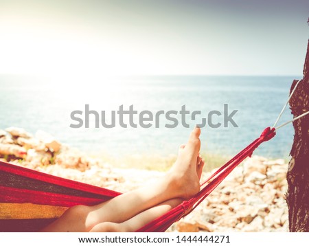 hammock chilling - image shows feed in hammock with nice sea view and beach - backlight situation best picture for travel agency or vacation planer