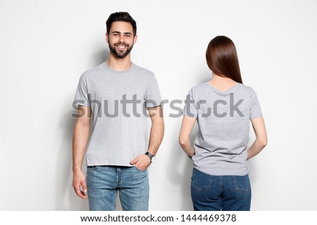 Young people in t-shirts on light background. Mock up for design