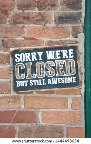 Sorry we're closed but still awesome signboard posted in a brick wall near the door