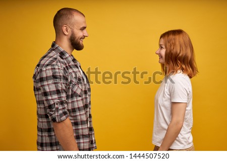 Profile side view portrait of nice lovely charming attractive cheerful flirty couple looking at each other talk conversation connection soulmate isolated over yellow background Royalty-Free Stock Photo #1444507520