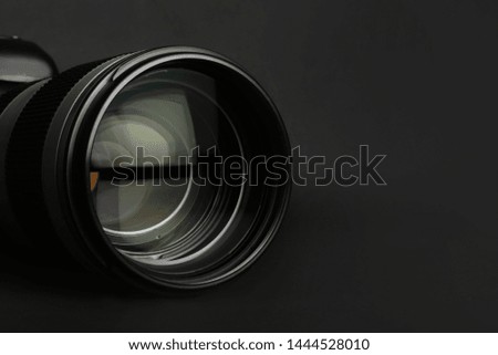 Modern camera lens on black background, closeup. Space for text