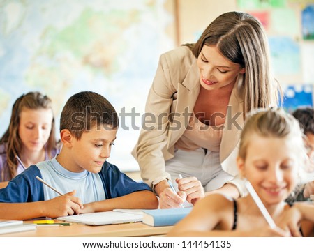 A teacher helping one of her students in class.